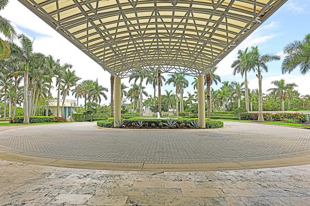 Canopy-covered entryway featuring a circular paver driveway