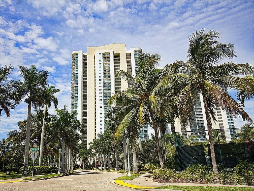 High-rise building exterior featuring a curved architectural element and numerous balconies
