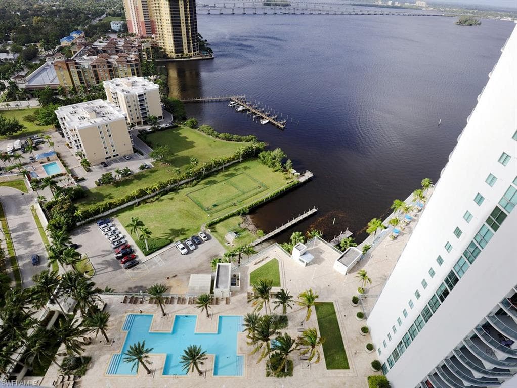 Aerial perspective showcasing multiple buildings, expansive waterfront, and extensive community amenities