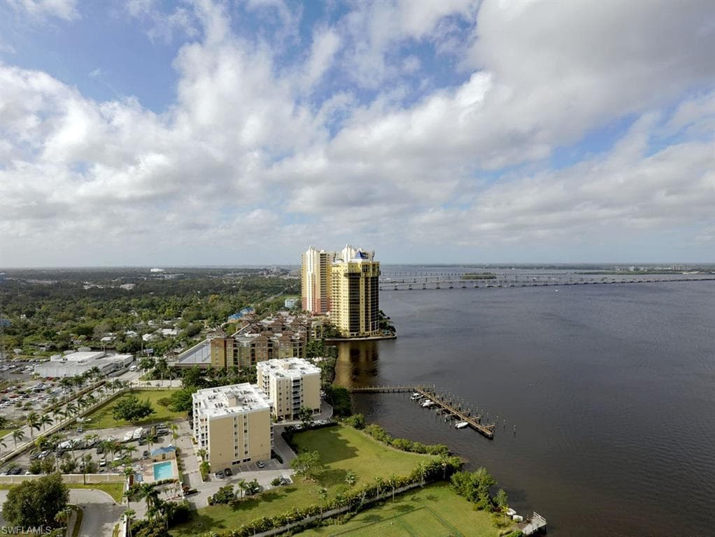 Aerial perspective featuring a multi-story building complex with waterfront access