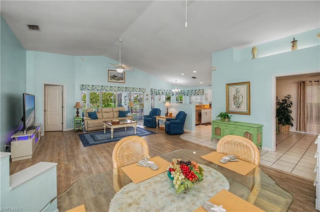 Expansive open-concept living area featuring vaulted ceilings and wood-finish flooring