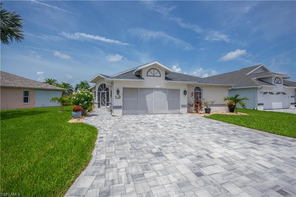 Sleek paver driveway with a curved walkway leading to the entry