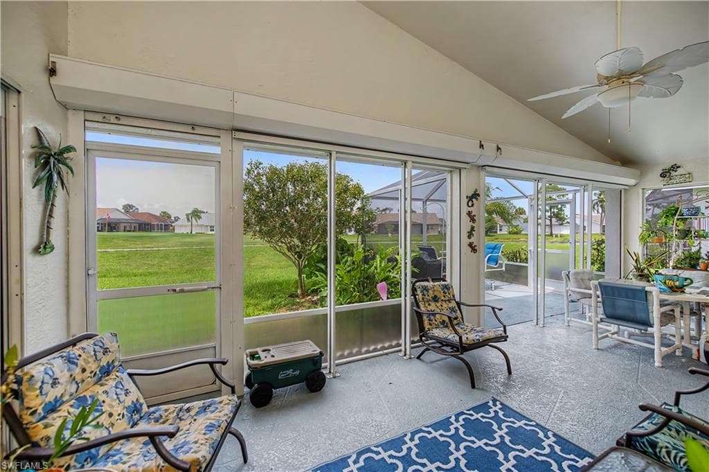 Screened-in patio with vaulted ceiling, ceiling fan, and tiled flooring