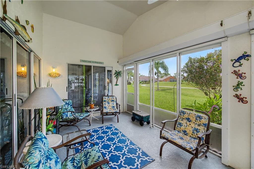 Screened porch with vaulted ceiling, featuring large sliding glass doors, a ceiling fan, and direct access to the outdoors
