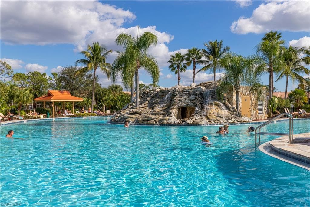 FALLING WATER RESIDENTS EXPERIENCING A REFRESHING SWIM AND THE USE OF LOUNGES, TABLES AND CHAIRS.