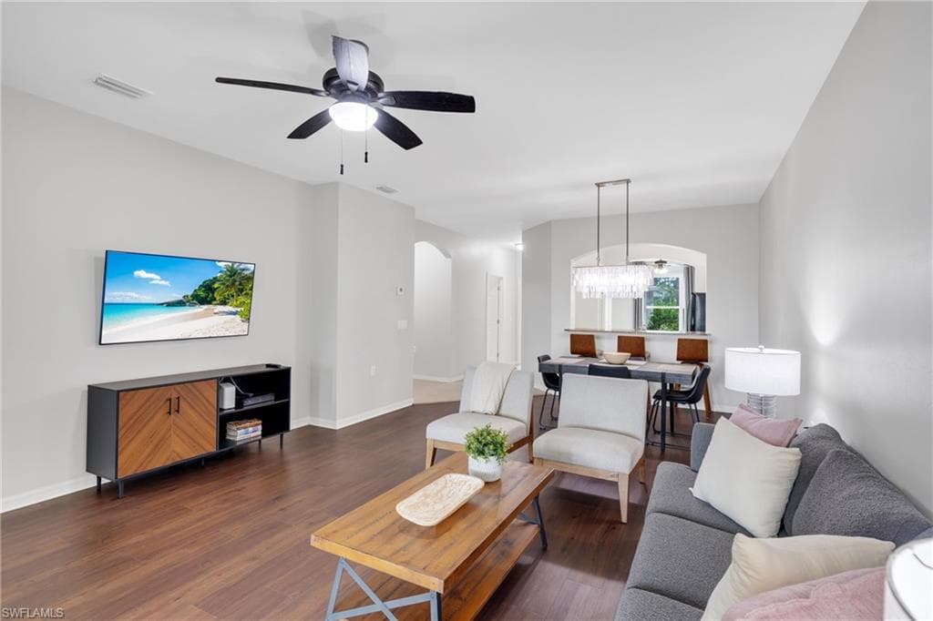 Open-concept living space featuring wood-finish flooring, a contemporary ceiling fan, and light gray wall tones