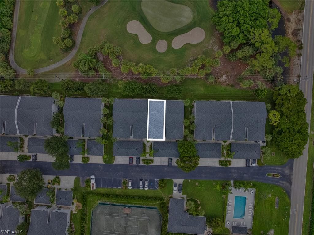 Aerial perspective of a multi-unit residential property situated alongside a golf course