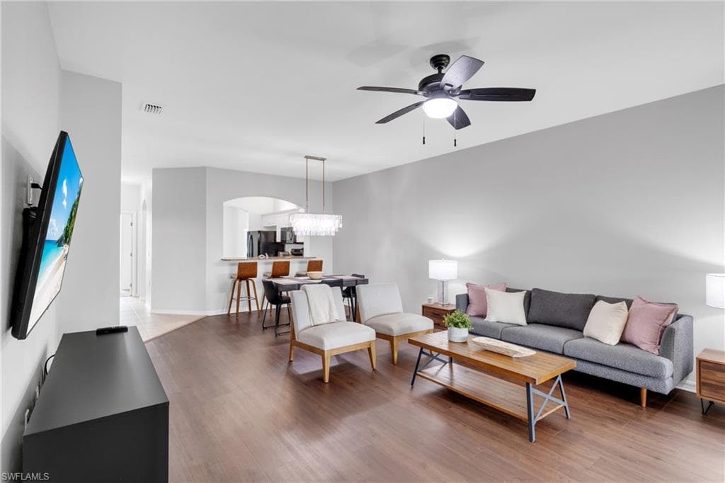 Open-concept living area with wood-finish flooring, recessed lighting, and a ceiling fan