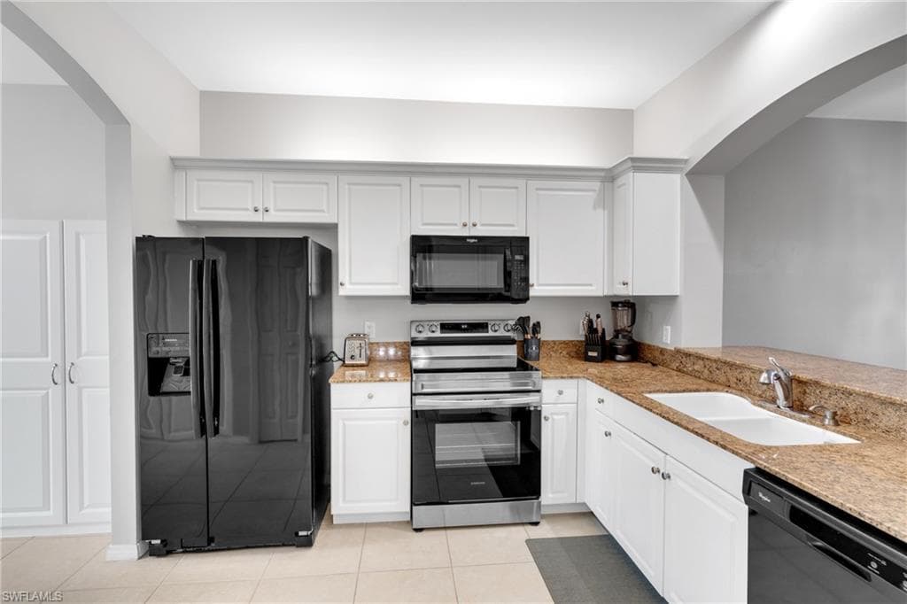 Well-appointed kitchen featuring white cabinetry, granite countertops, and stainless steel appliances including an oven and microwave