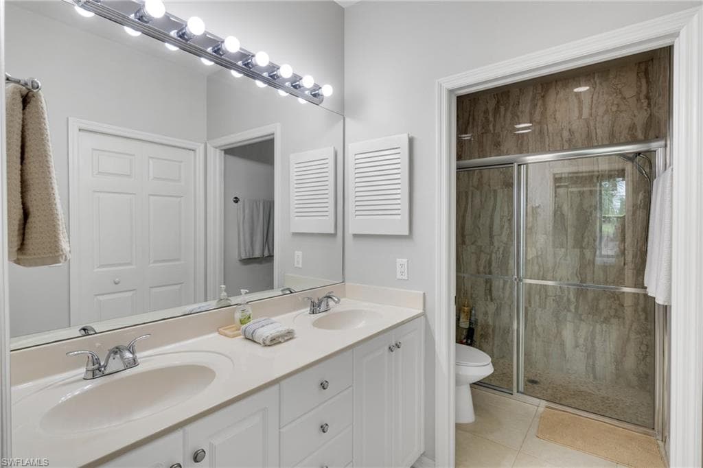 Double vanity with integrated sinks, chrome fixtures, and white cabinetry