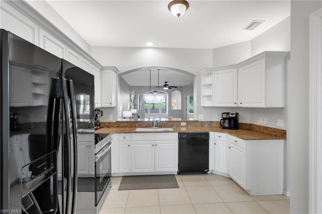 Kitchen featuring white cabinetry, granite countertops, black appliances, and tile flooring
