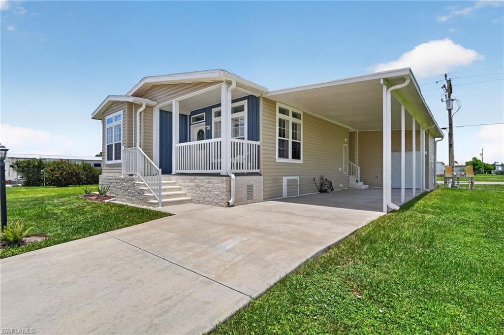 Single-story residence featuring light tan siding with a contrasting blue accent wall on the front porch