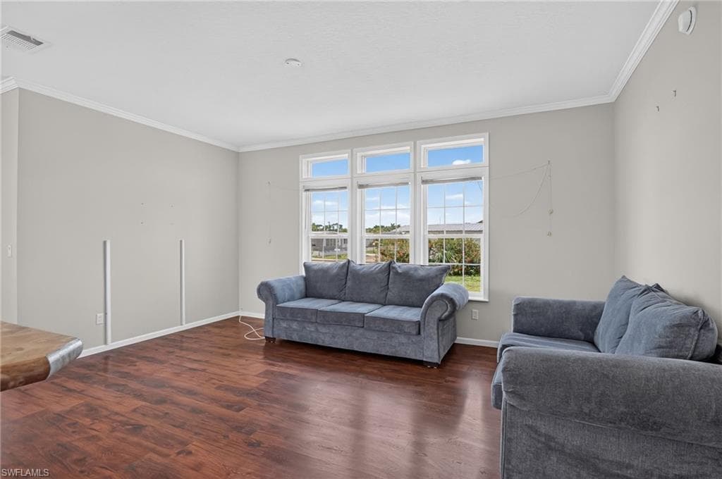 Living area featuring expansive windows, wood-finish flooring, light gray walls, white crown molding, and white baseboards