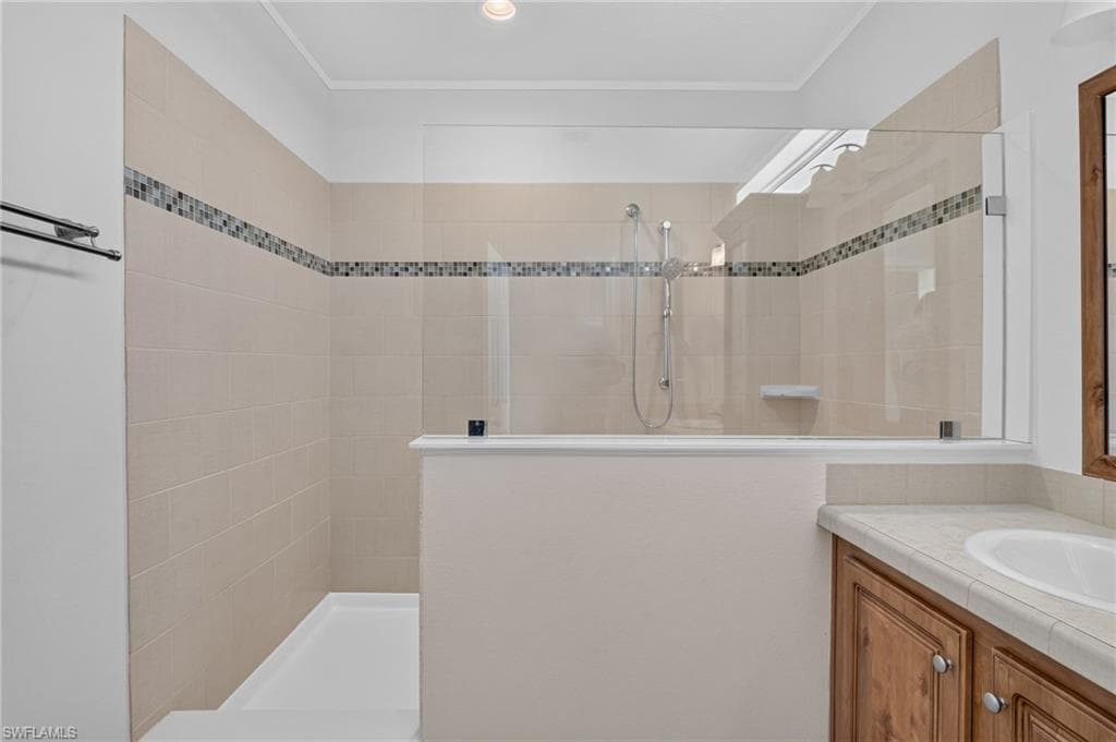 Owners Suite Shower, Tiled shower with glass enclosure, mosaic accent band, and integrated shower head
