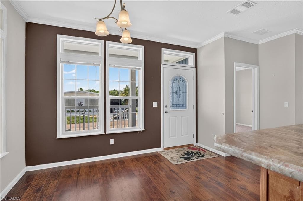Entry area featuring wood-finish flooring, a decorative glass door with transom window, and two large windows with mullions