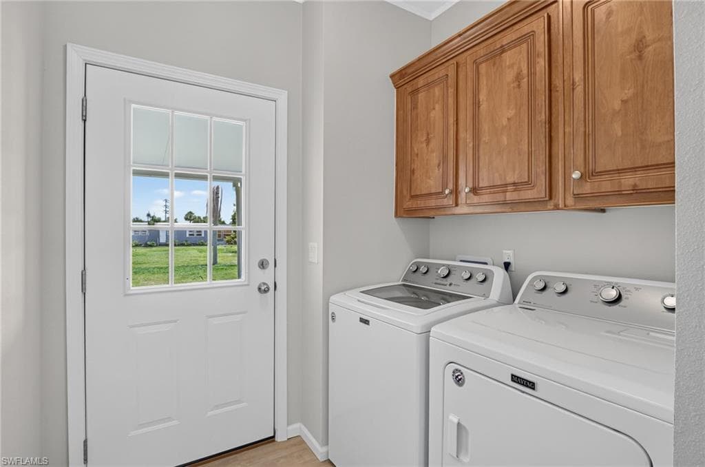 Dedicated laundry area featuring overhead wood cabinetry and a glass-paned door