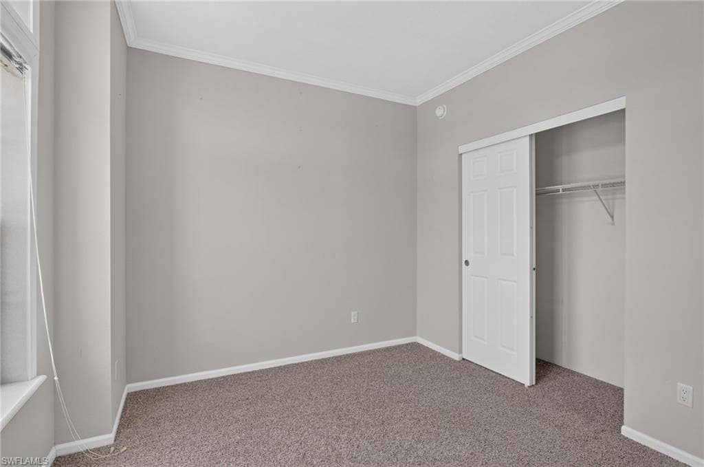 Bedroom 1, featuring neutral wall tones and crown molding