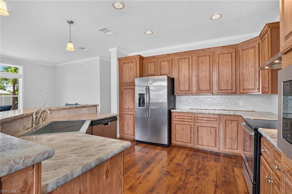 Kitchen featuring wood-finish flooring, custom wood cabinetry, and stone countertops