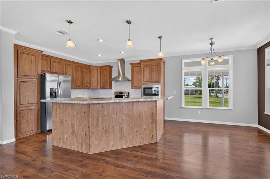 Kitchen featuring a large island with a stone-finish countertop, wood-finish flooring, and recessed lighting