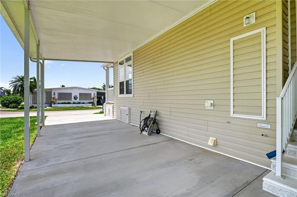 Covered carport with concrete paving, providing shelter and additional exterior space