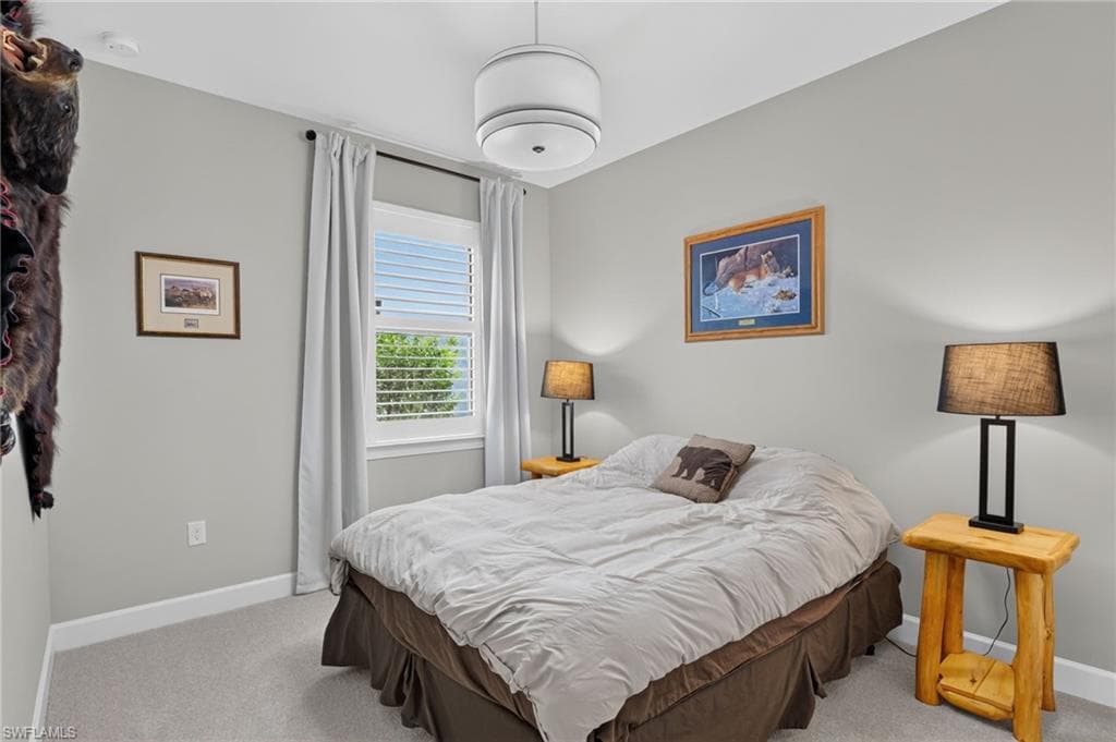 Bedroom featuring neutral wall paint, white trim, and light gray carpeting