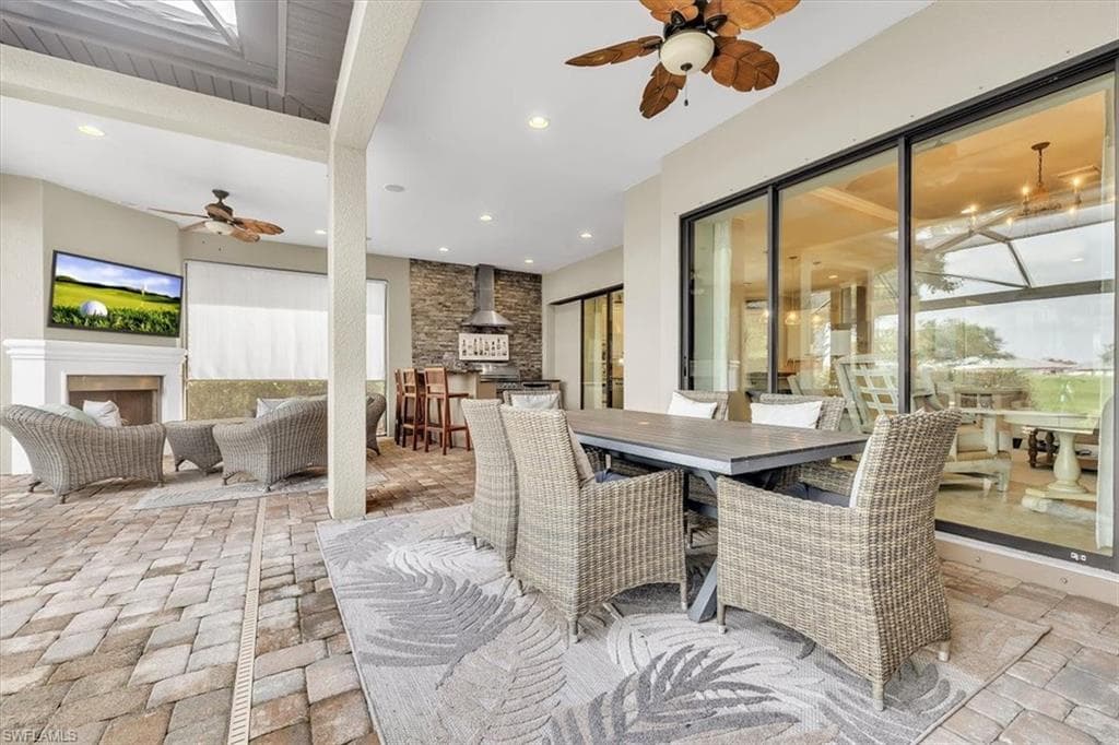 Lanai featuring outdoor kitchen, fireplace, privacy shade, pool/spa, and view of #1 fairway and green