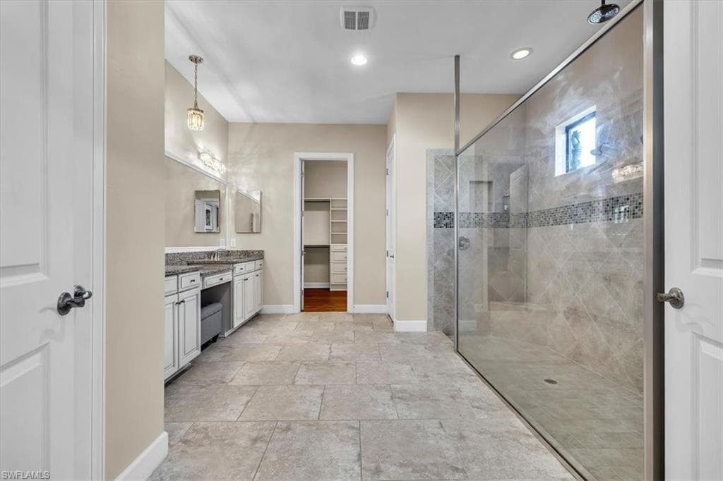 -featuring an oversized walk in shower, double sinks, and a make-up vanity