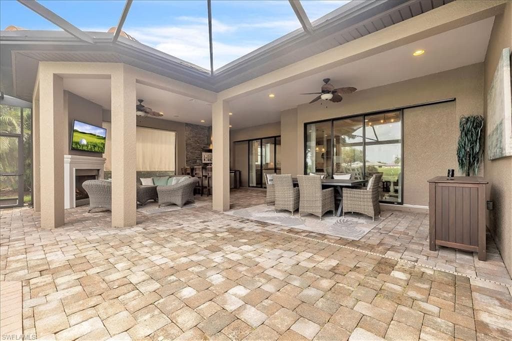 Lanai featuring outdoor kitchen, fireplace, privacy shade, pool/spa, and view of #1 fairway and green