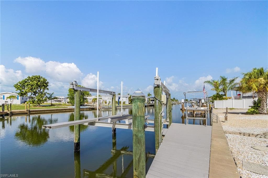 Waterfront canal with a private dock featuring a boat lift