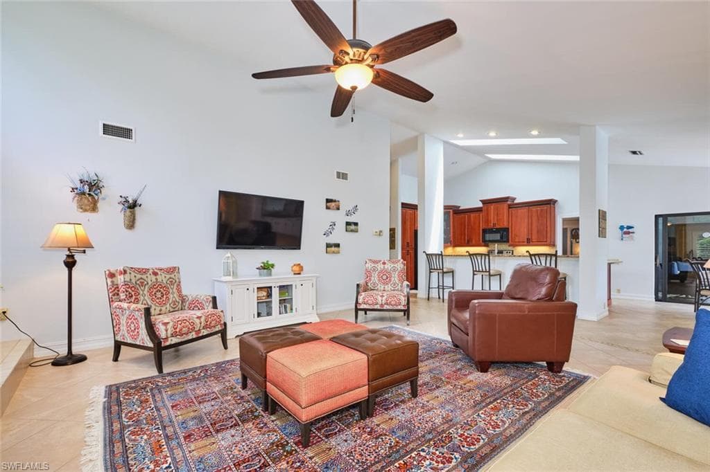 Spacious great room with lighted ceiling fan, high ceilings, open concept floor plan.