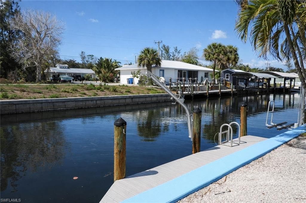 Waterfront property featuring a private boat dock, boat lift, and seawall
