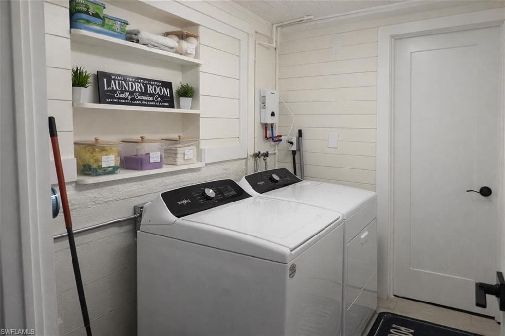 Dedicated laundry area featuring a white shaker-style door, shiplap wall paneling, built-in shelving, and a water heater
