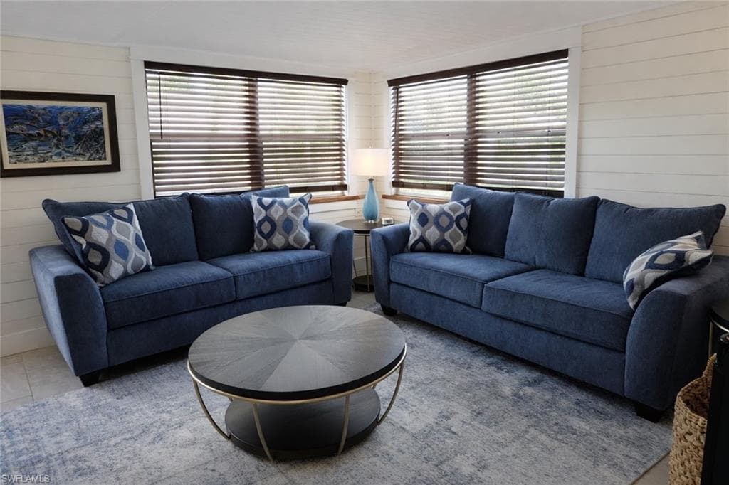 Two large windows featuring dark wood-finish blinds