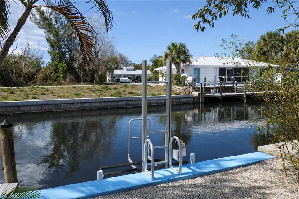 Waterfront property featuring a private boat dock, boat lift, and direct canal access