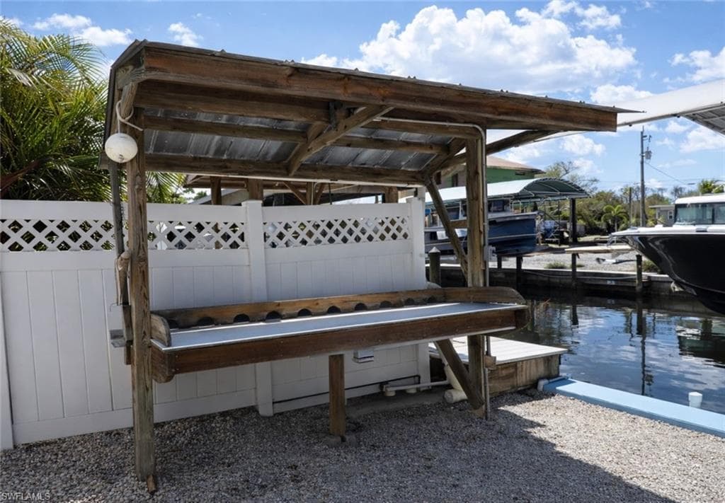 Waterfront property featuring a wood-framed covered outdoor workstation with a metal roof