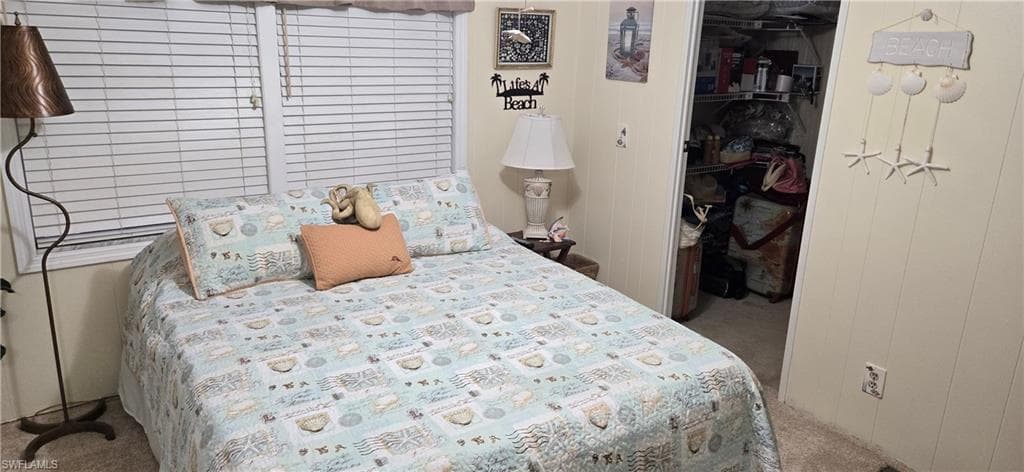 Bedroom featuring panel walls and a window with horizontal blinds