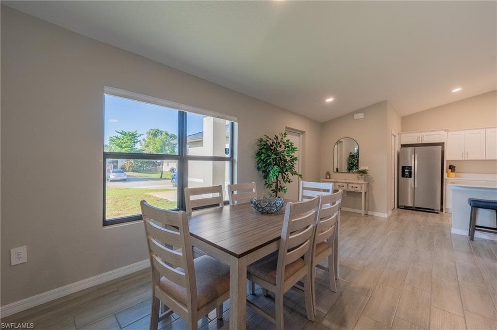 Dining area featuring a large window, recessed lighting, and wood-finish flooring