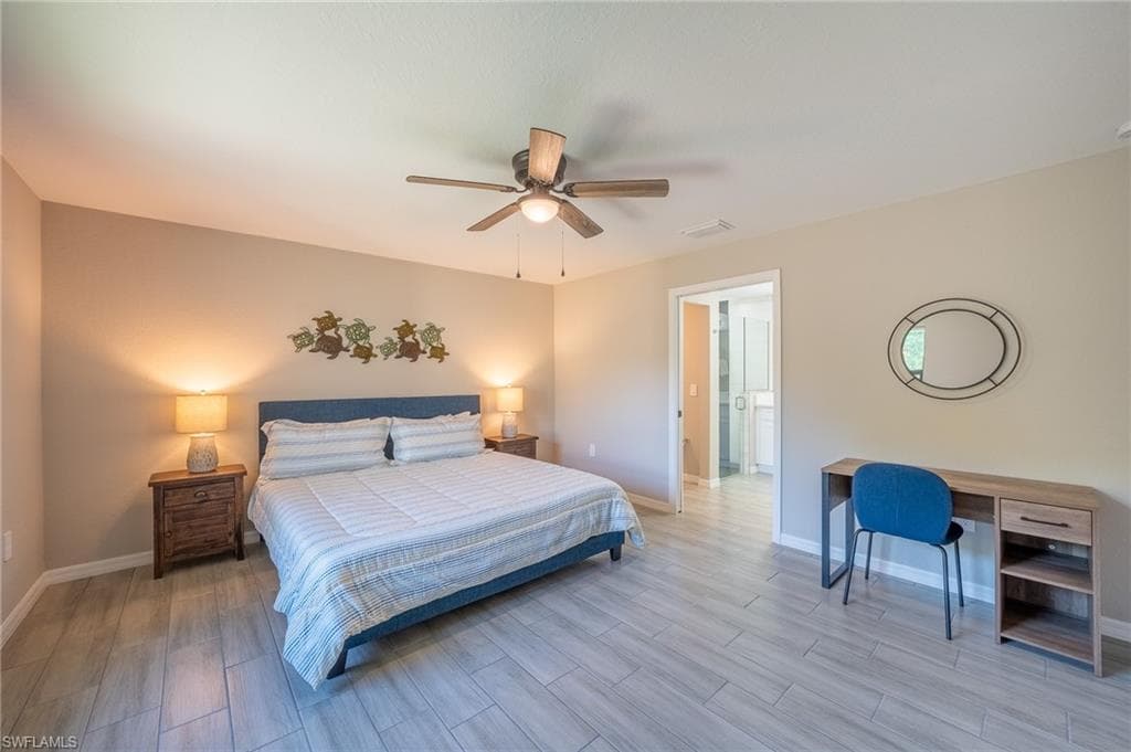 Spacious room featuring wood-finish tile flooring, a sloped ceiling, and a ceiling fan with integrated lighting