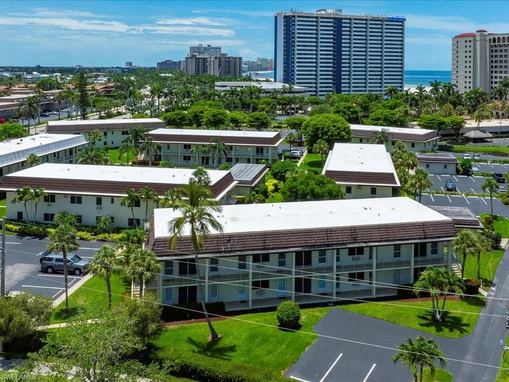 Multi-story buildings featuring white exteriors and brown roofs