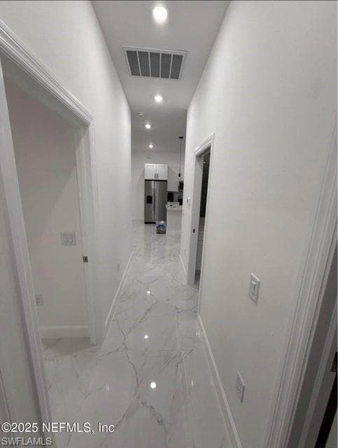 Corridor featuring recessed lighting and light marble finish floors
