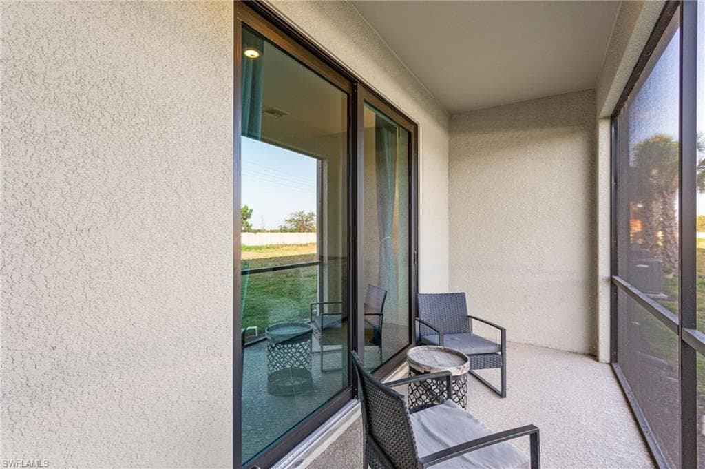Private screened lanai overlooking the peaceful green space, complete with a convenient outdoor storage room