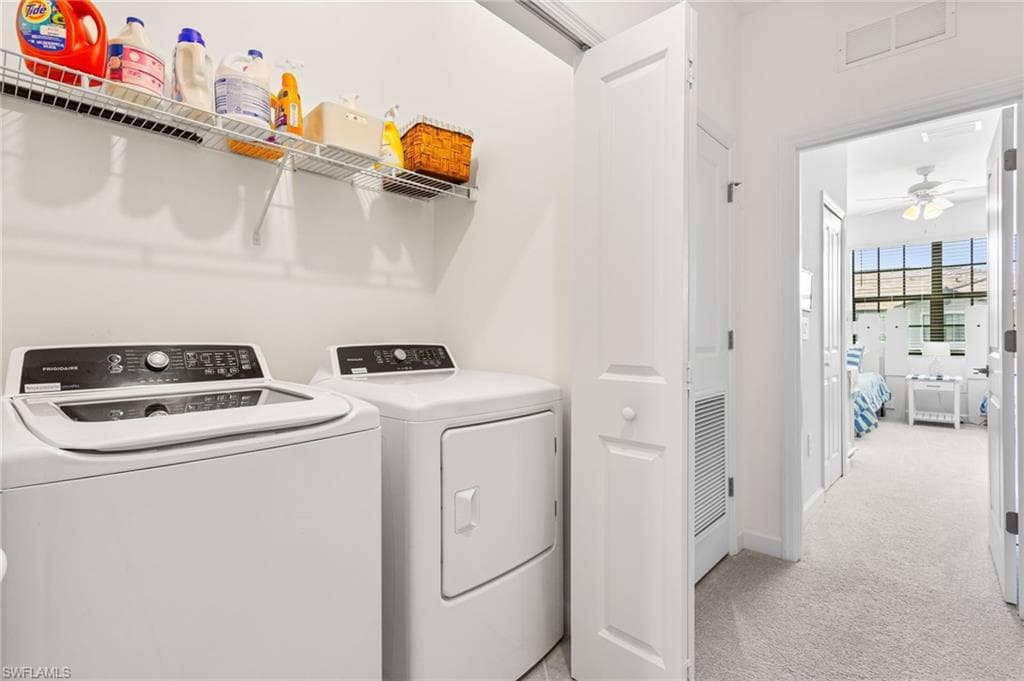 The upstairs laundry area is equipped with a washer, dryer, and shelving for supplies