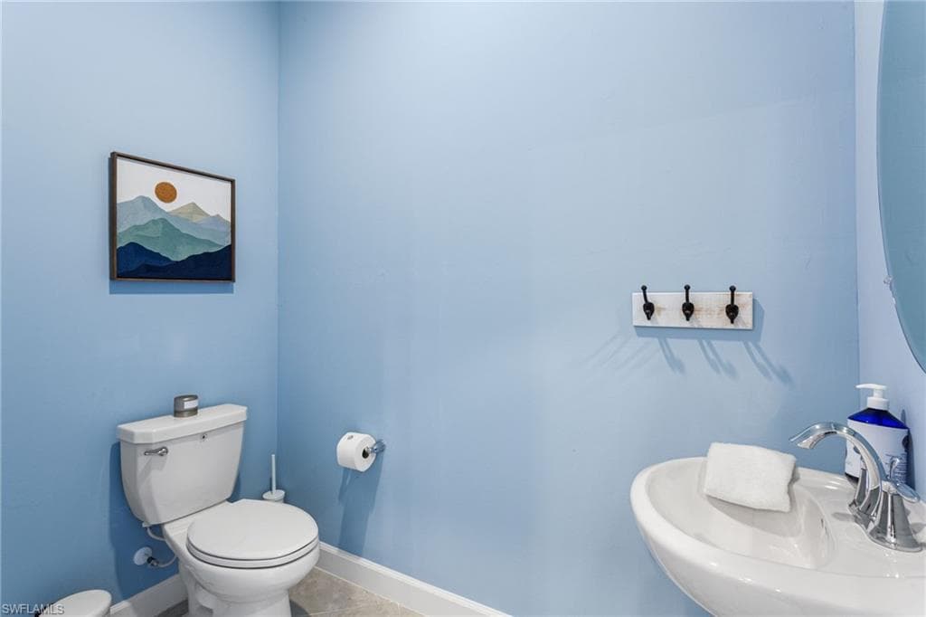 Convenient half bathroom located near the main entrance, perfect for guests