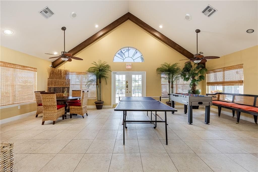 Spacious communal area featuring an exposed beam vaulted ceiling, recessed lighting, and ceiling fans