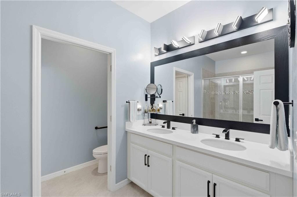 Double vanity featuring white cabinetry with black hardware, white countertops, and dual undermount sinks with matte black faucets