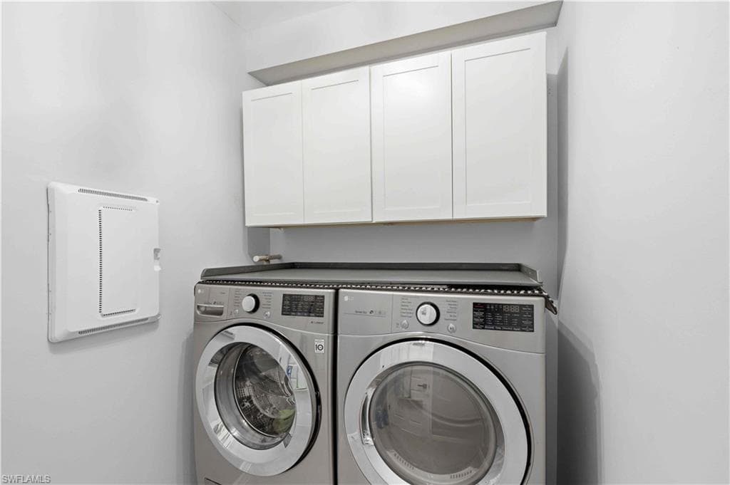 Laundry area featuring white shaker-style cabinetry, a built-in countertop above appliances, and light neutral wall finishes. Washer and Dryer, do not convey.