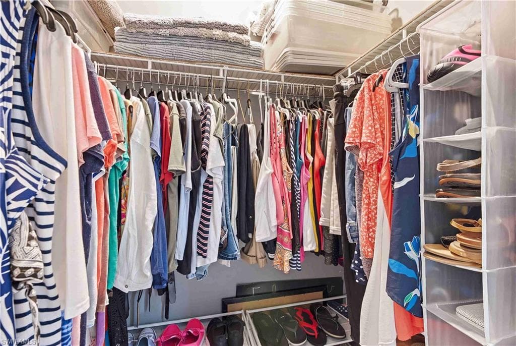 Walk-in closet featuring built-in wire shelving, ample hanging rods, and integrated overhead storage solutions