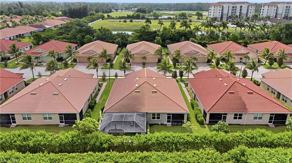 Aerial perspective showcasing properties with tiled roofs and screened rear patios