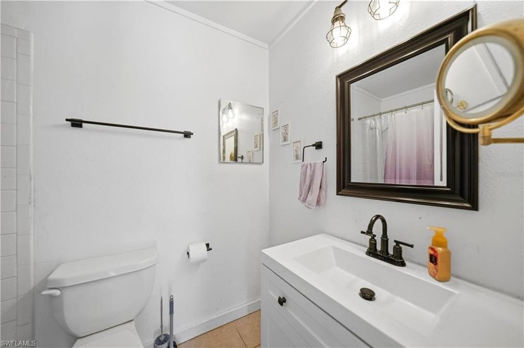 Bathroom featuring a white vanity with integrated sink, dark bronze faucet, and a coordinating framed mirror