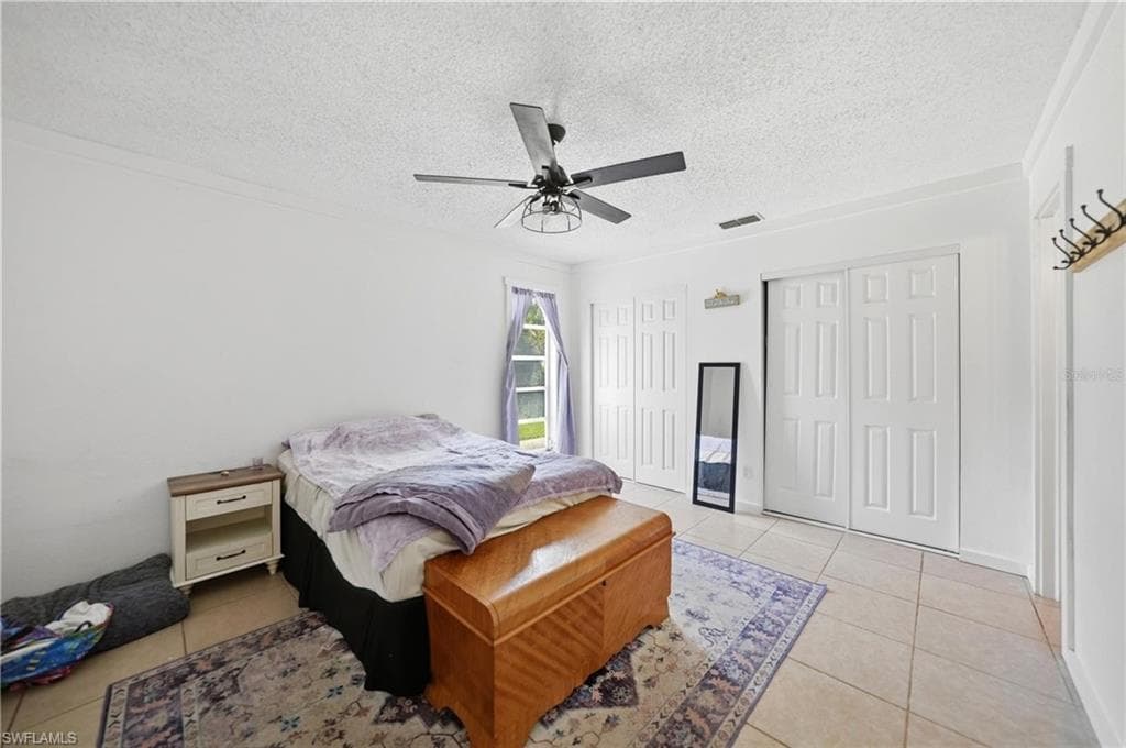 Bright room with tile flooring and a ceiling fan